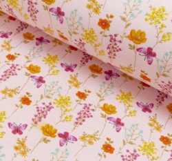 Warmkeeper motýlci mezi kvítky na světlé broskvové