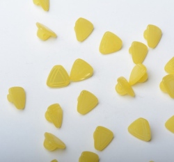 Knoflík ve tvaru trojúhelníku, po stranách rýhovaný žlutý